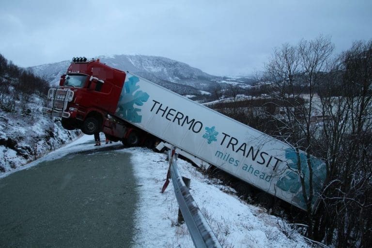 Her lener laksetraileren seg mot et tre. Fra veibanen går det en bratt skråning på 50 meter rett ned
